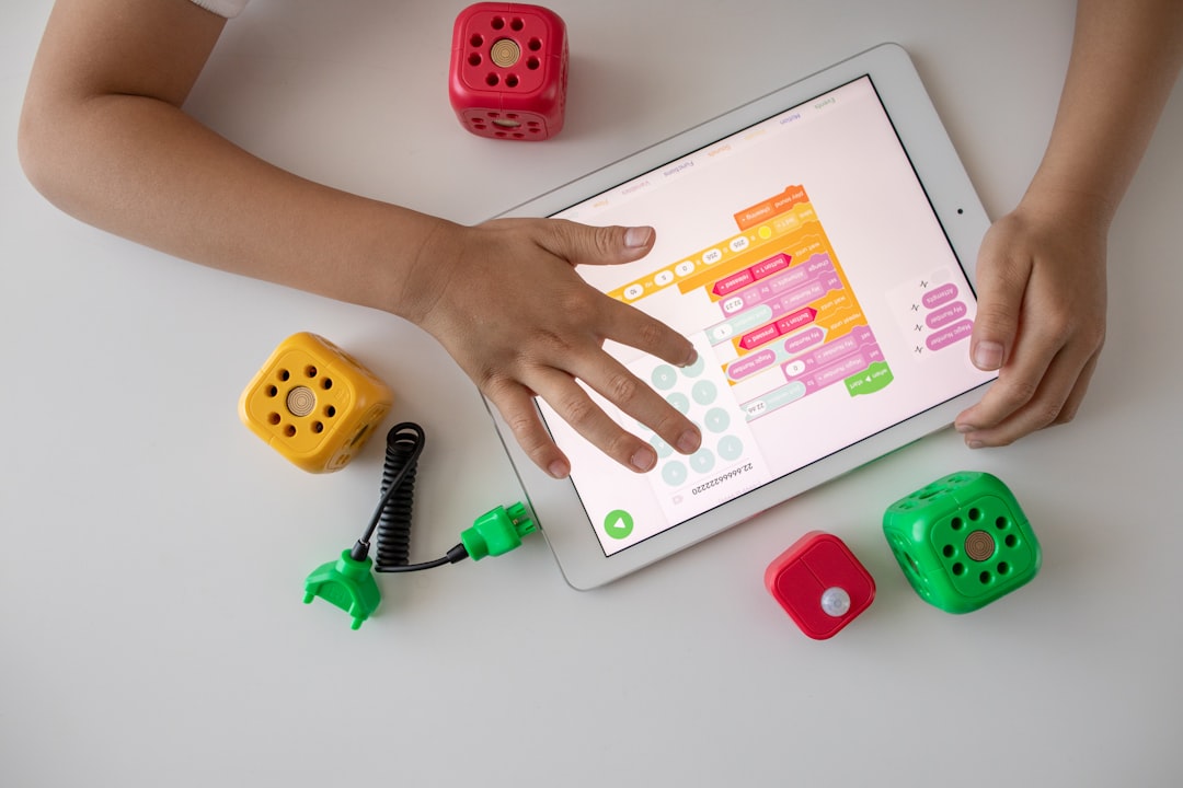 A child engaged in a hands-on STEM activity using a tablet, surrounded by educational tools and materials.