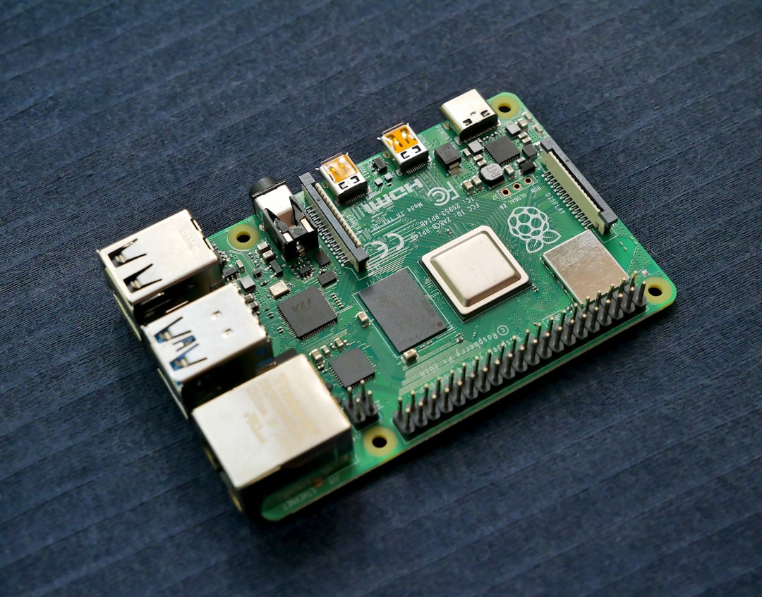 A Raspberry Pi board with accessories like cables, breadboard, and electronic components on a wooden desk.